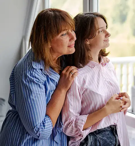two woman looking at the window
